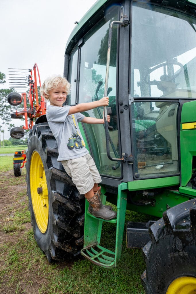 Lindale Farms' Mason Lindley climbs the steps of a tractor on the family farm.