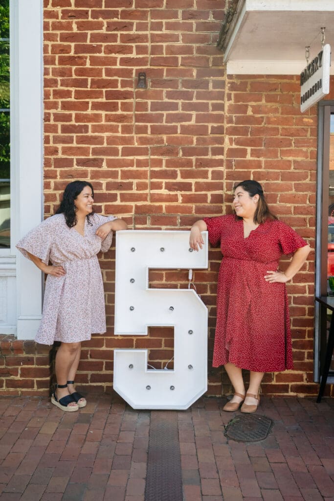 Carolina Cravings Co. owners Yeraldyn Martinez and Iliana Escalante in front of their Pittsboro bakery, Chatham Magazine