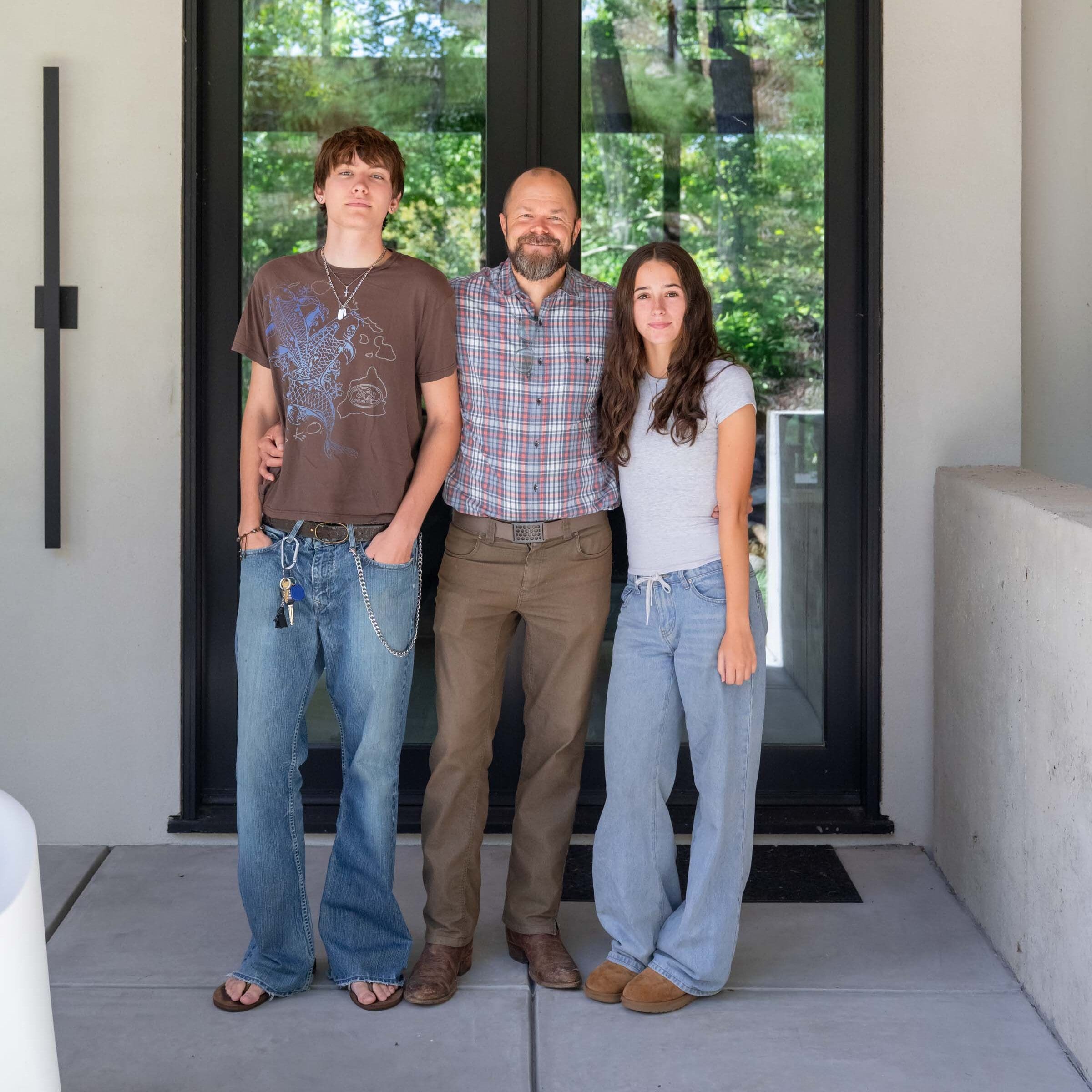 Jason Dell and his kids stand in front of their custom-designed home.