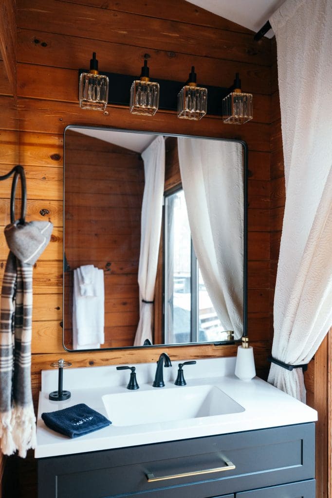 A bathroom in the Loblolly House is brightened by natural lighting through the large windows. 