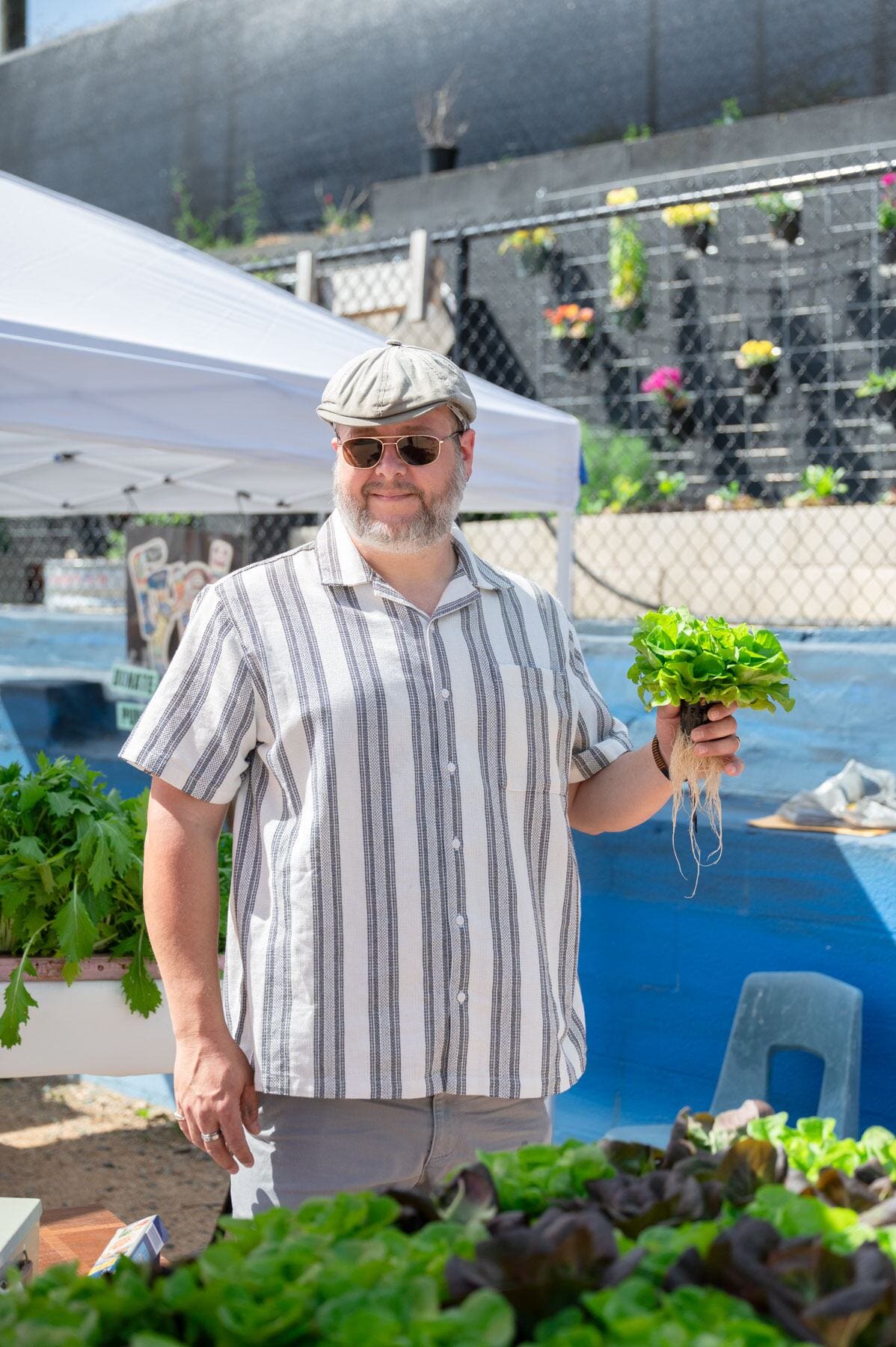 Wes Lail of Academy Farm poses for a portrait with a head of lettuce at the Pittsboro Farmer's Market 
