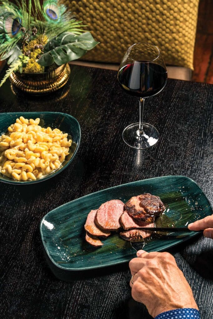 USDA Prime steak and mac and cheese with a glass of red wine from Best of Chatham County restaurant The Sycamore at Chatham Mills. 