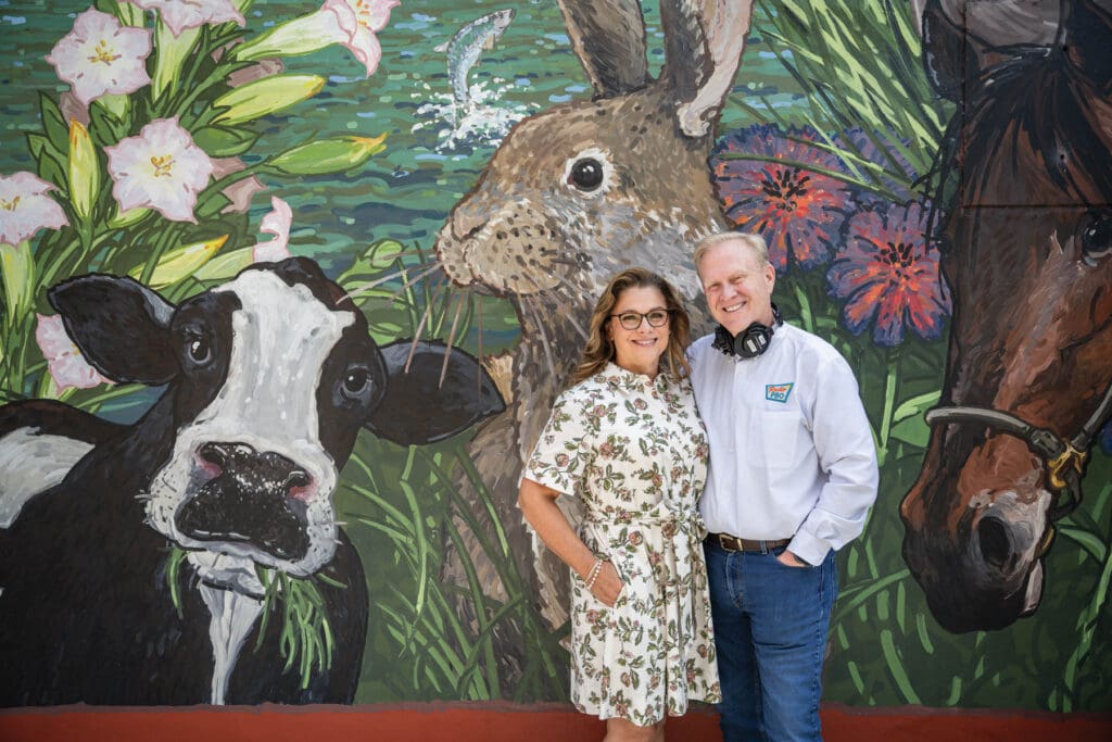 Husband and wife duo by mural.
