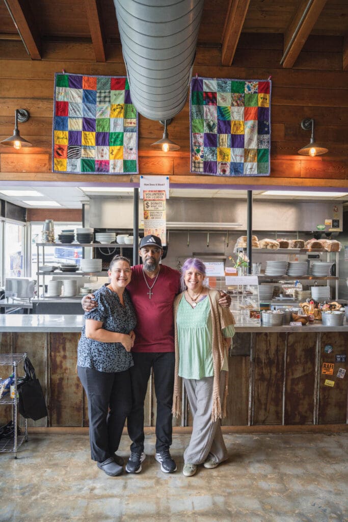 Three employees hugging.
